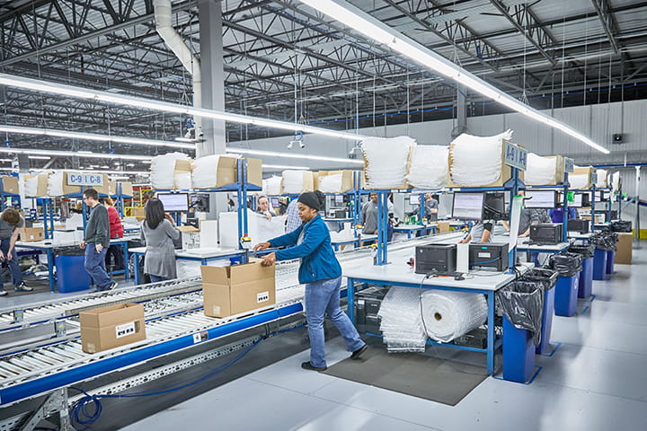 Woman packing boxes at our distribution center