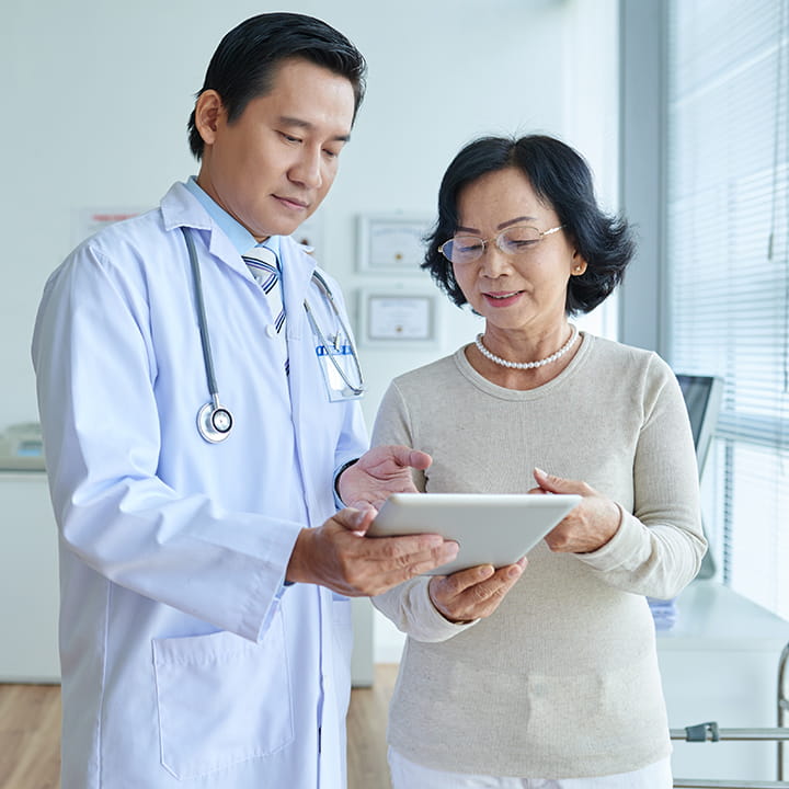 Doctor and patient examining a computer tablet