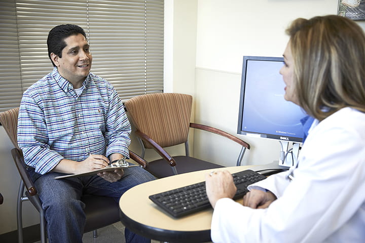 Patient filling in form with doctor